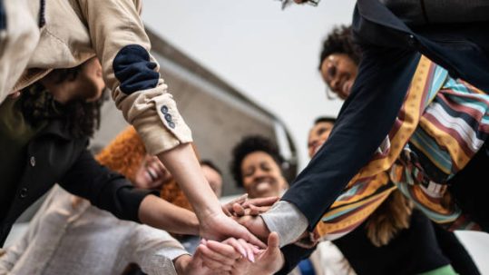 Coworkers with stacked hands at the office